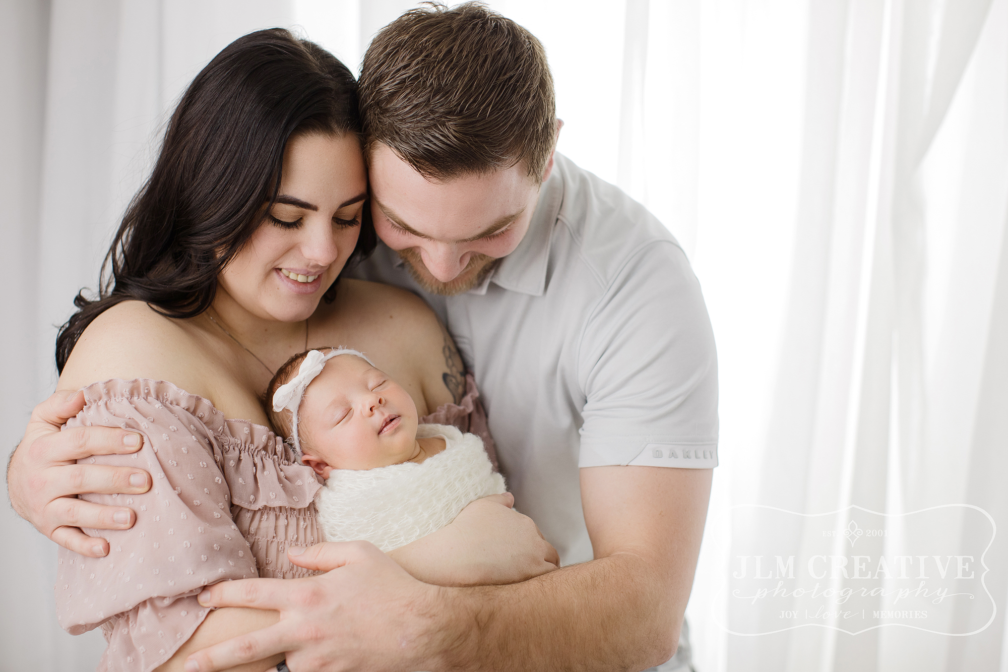 Family with new baby on white background