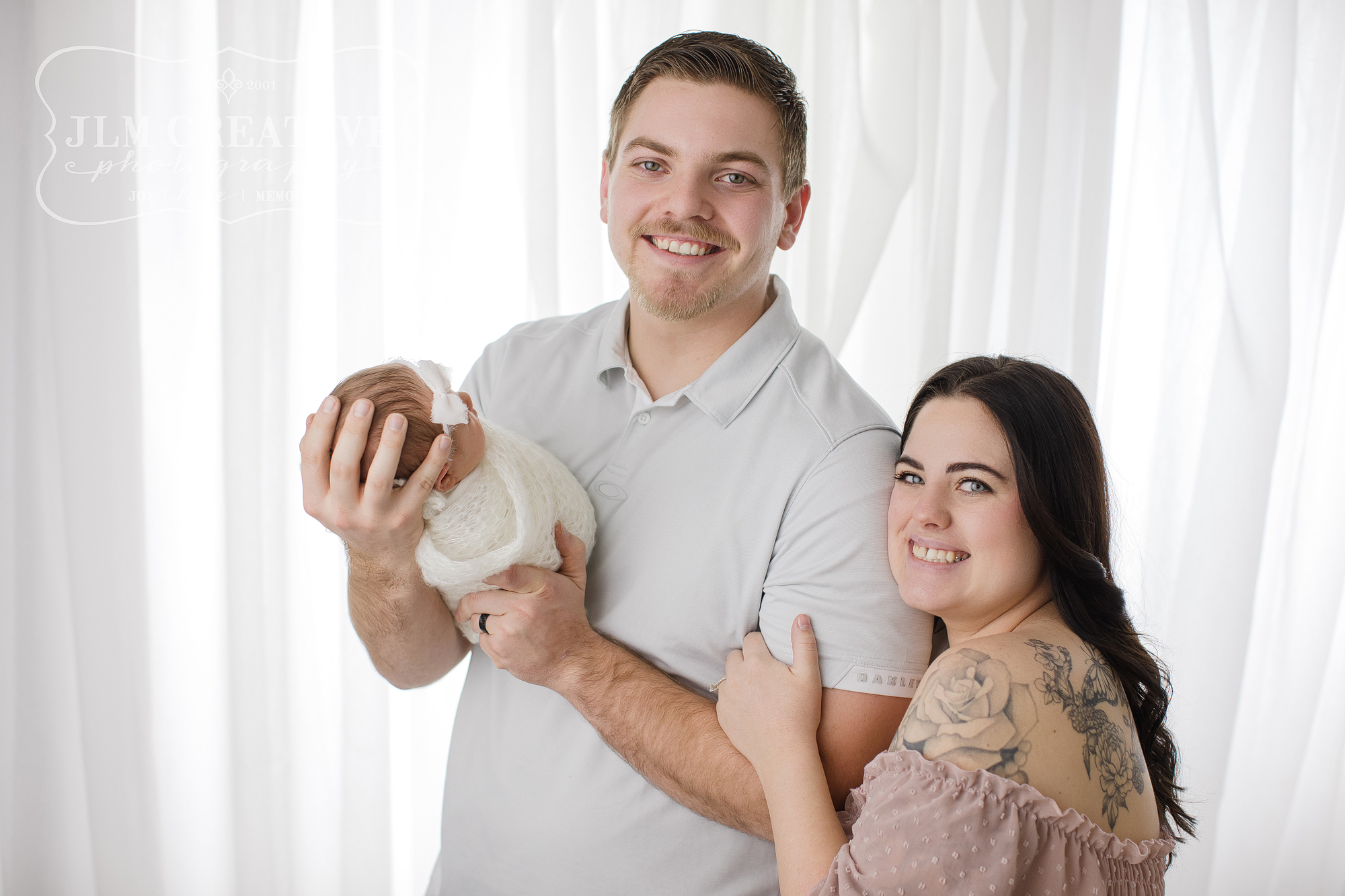 Family with new baby on white background